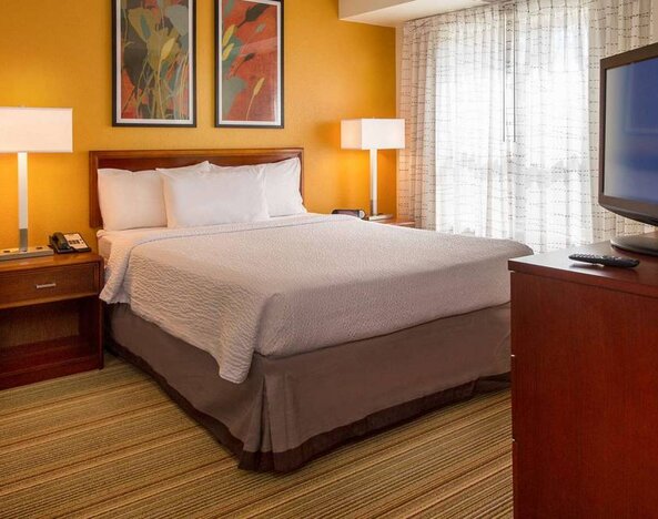 Double bed guest room in Sonesta ES Suites Charlottesville University, featuring window and widescreen TV.