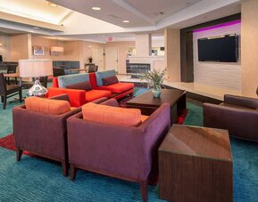 The hotel’s lobby lounge features comfortable chairs facing a widescreen, wall-mounted TV, with coffee tables close at hand.