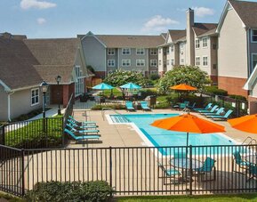 Sonesta ES Suites Baltimore BWI Airport’s outdoor pool is ringed by a fence, within which there are sun loungers, plus shaded tables and chairs.