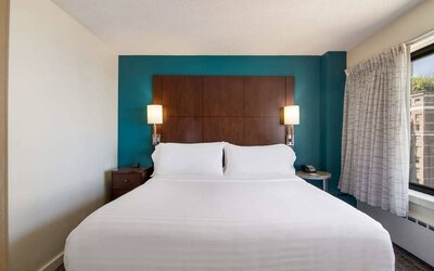 Double bed guest room in Sonesta ES Suites Chicago Downtown Magnificent Mile - Medical, with bedside lamps and window.