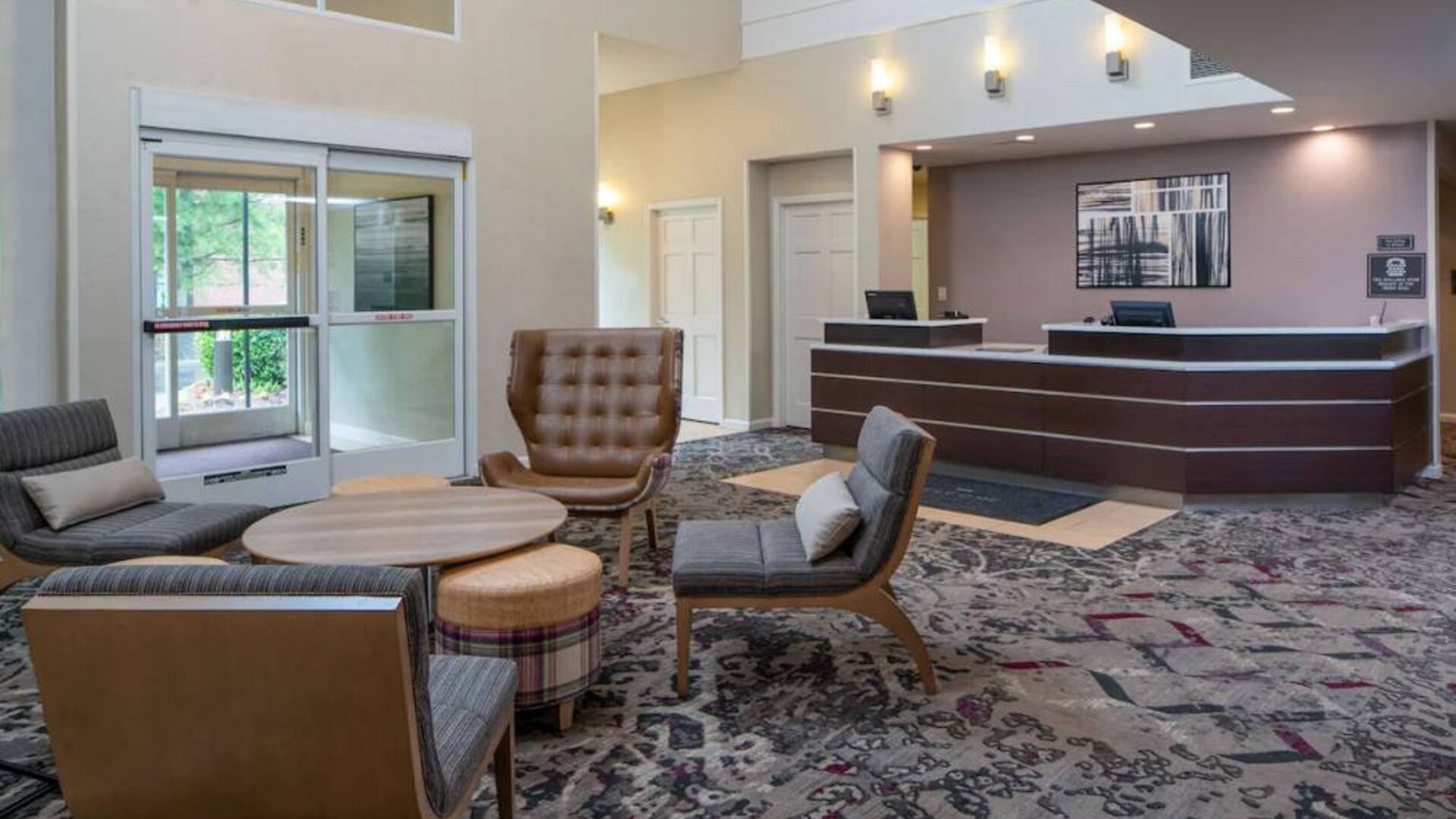 The lounge in Sonesta ES Suites Nashville Brentwood’s lobby features a quartet of comfy chairs, a snazzy carpet, and a coffee table. 