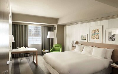 Royal Sonesta Minneapolis Downtown deluxe king guest room, with workspace desk and chair, and art on the wall.