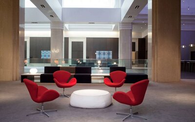 Royal Sonesta Minneapolis Downtown co-working space, furnished with coffee table and stylish red chairs, with sofas nearby.