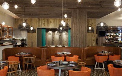 Royal Sonesta Minneapolis Downtown restaurant, with small tables for dining and working lunches, and a bar close at hand.