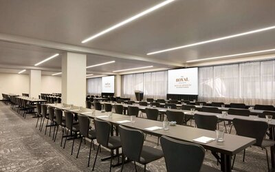 Large meeting room in Royal Sonesta Minneapolis Downtown, with lectern, large screens, and space for seating for several dozen attendees.