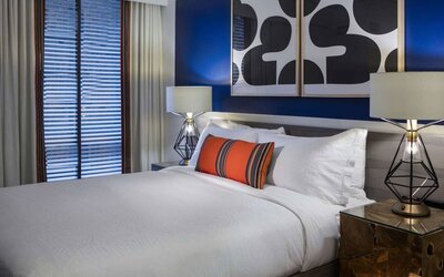 Royal Sonesta Washington DC Dupont Circle double bed guest room, featuring bedside lamps, art on the wall, and window.