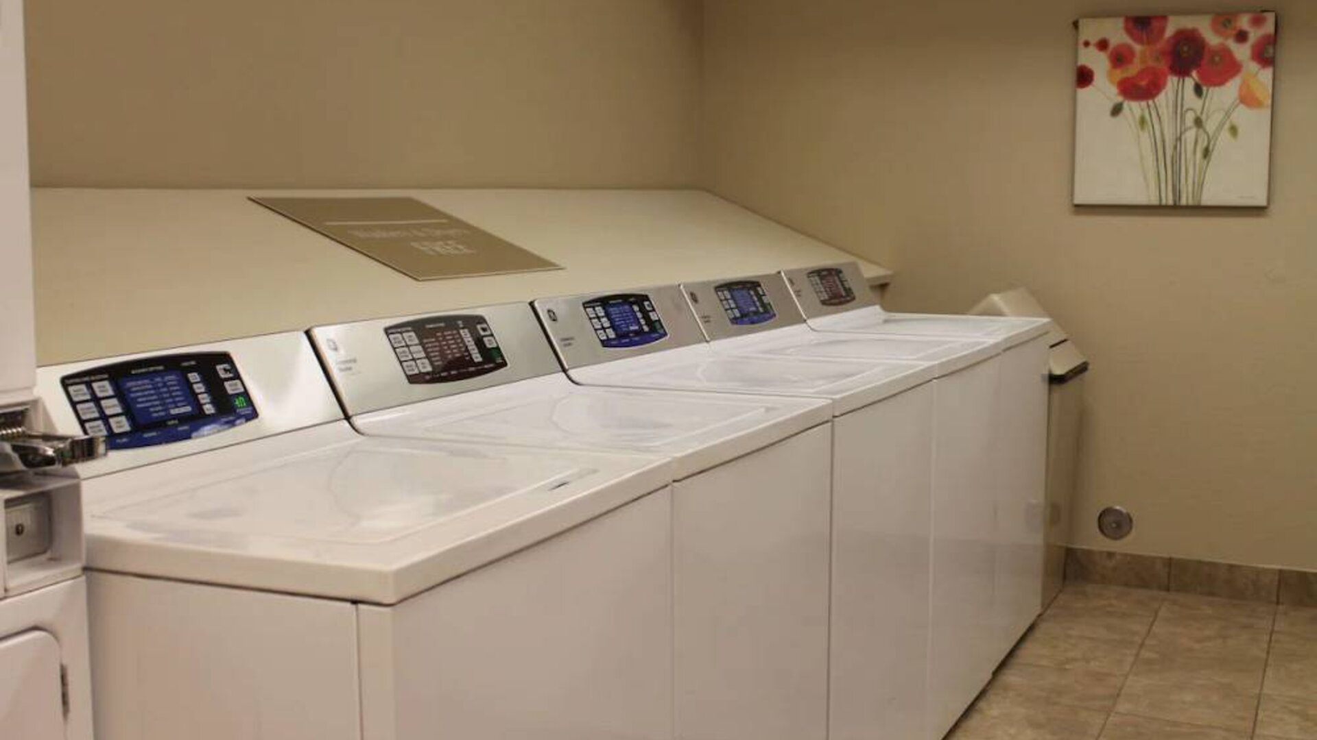 The hotel’s laundry room has numerous machines for guests to use, and art on the wall.
