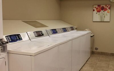 The hotel’s laundry room has numerous machines for guests to use, and art on the wall.