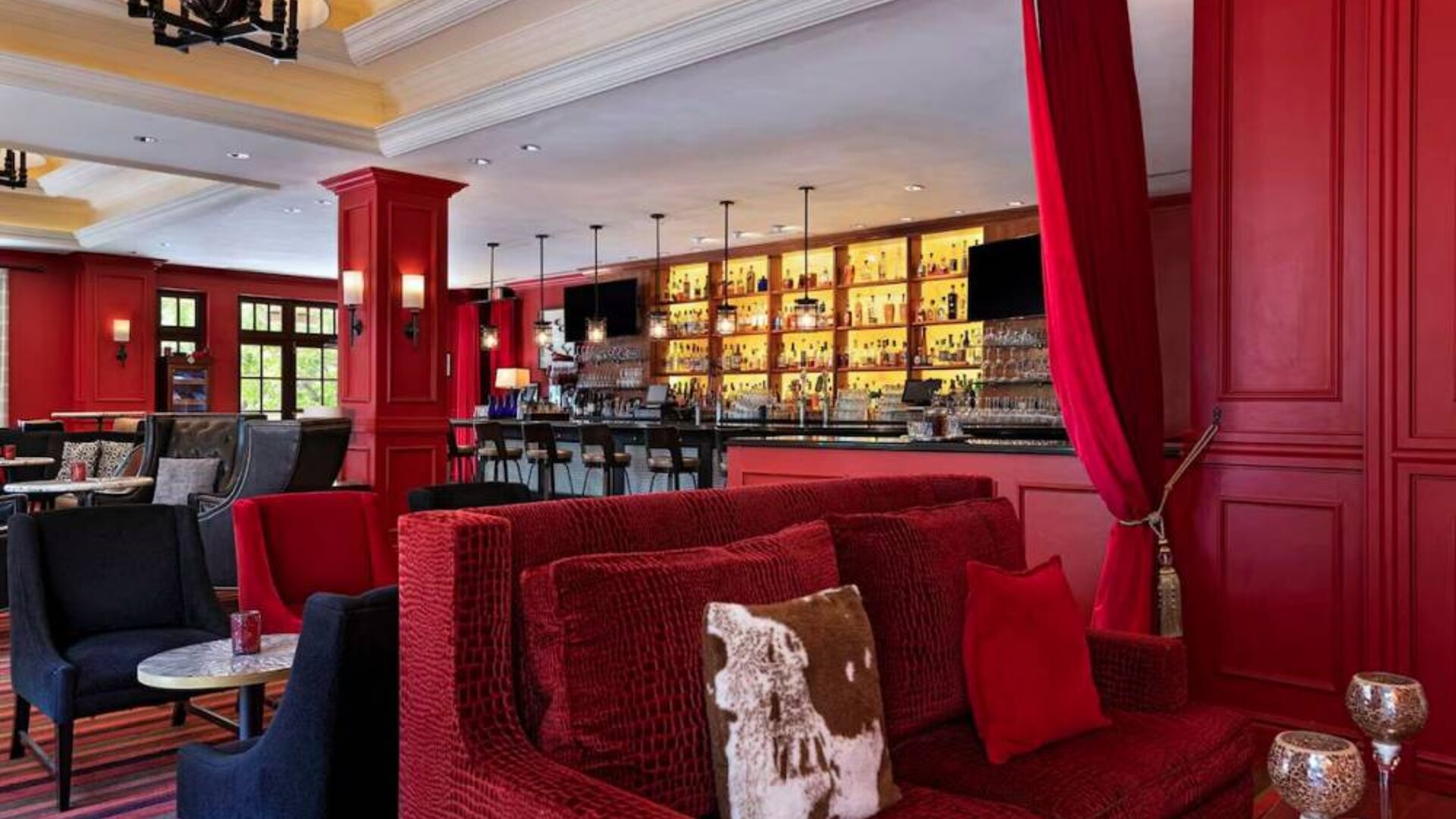 The Stephen F Austin Royal Sonesta Hotel’s bar has vibrant red decor, and a mix of comfortable table seating and traditional bar stools.