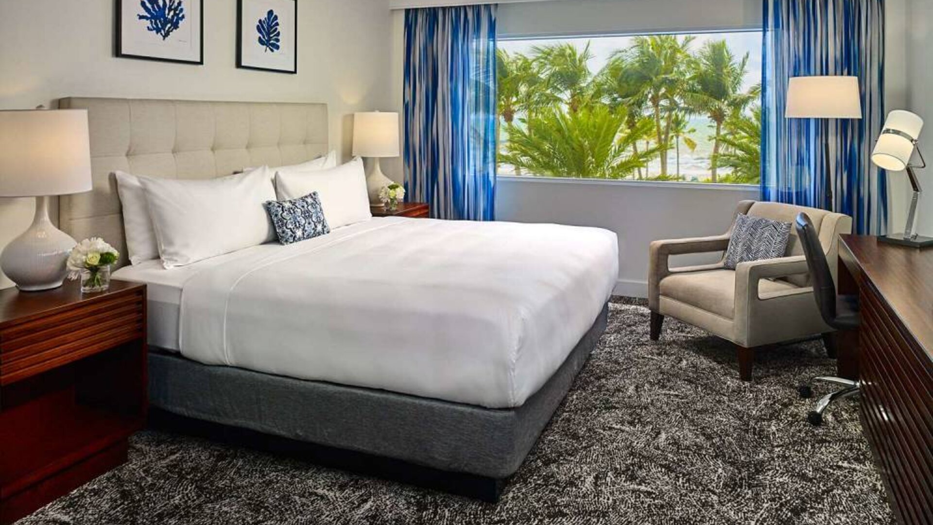 Double bed guest room in Sonesta Fort Lauderdale Beach, furnished with armchair plus workspace desk and chair.