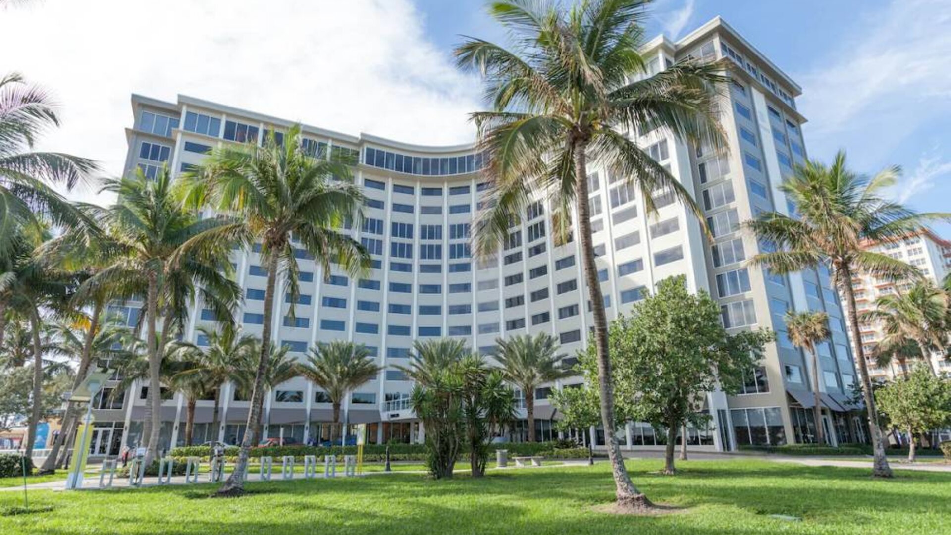 Sonesta Fort Lauderdale Beach’s exterior has extensive greenery, including numerous palm trees.