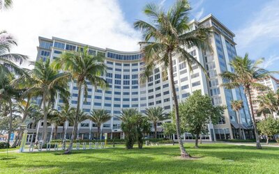 Sonesta Fort Lauderdale Beach’s exterior has extensive greenery, including numerous palm trees.