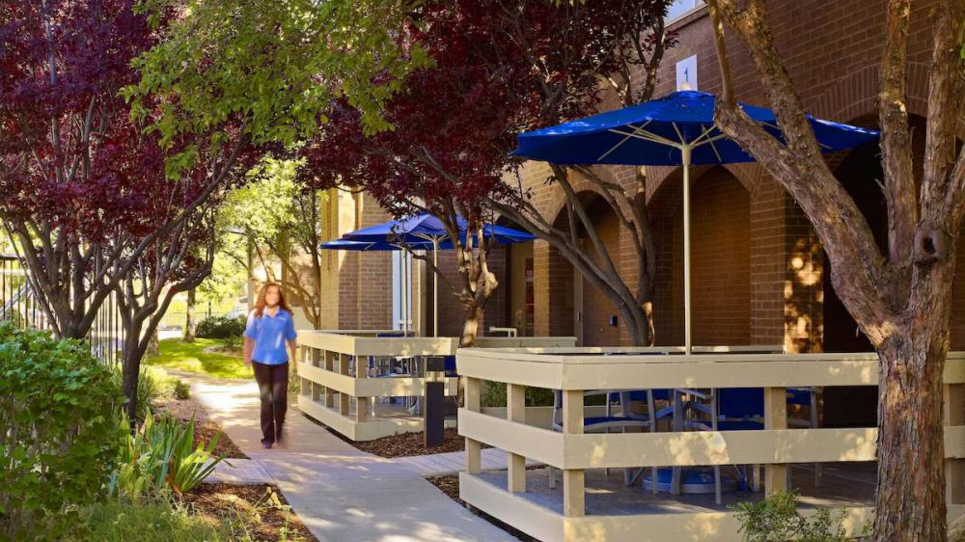 The hotel’s exterior has numerous trees and shaded table and chairs where guest can relax or co-work.