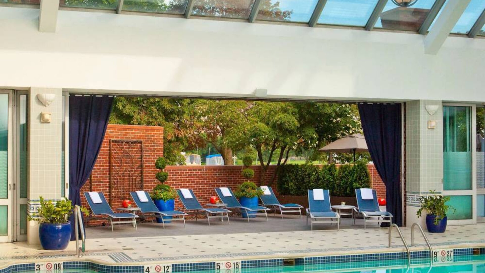 The indoor pool at Royal Sonesta Boston has plenty of natural light, with sun loungers and potted plants by the side.
