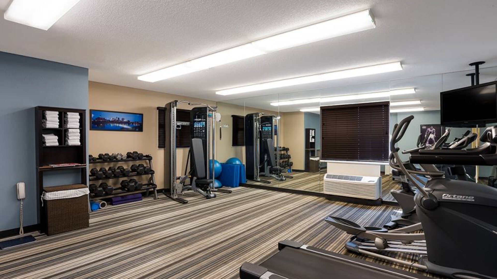 Sonesta Simply Suites Des Moines’ fitness center is equipped with rows of free weights, plus an assortment of exercise machines, and a TV.