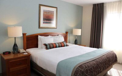 Sonesta ES Suites Portland Vancouver 41st Street double bed guest room, featuring art on the wall and a large window.