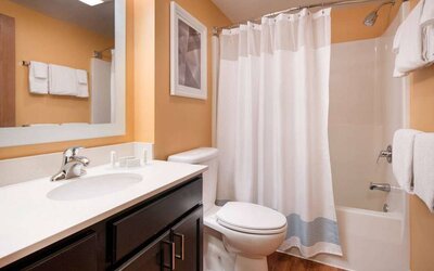 Sonesta Simply Suites Seattle Renton guest bathroom, furnished with bath and shower, lavatory, and mirror and sink.
