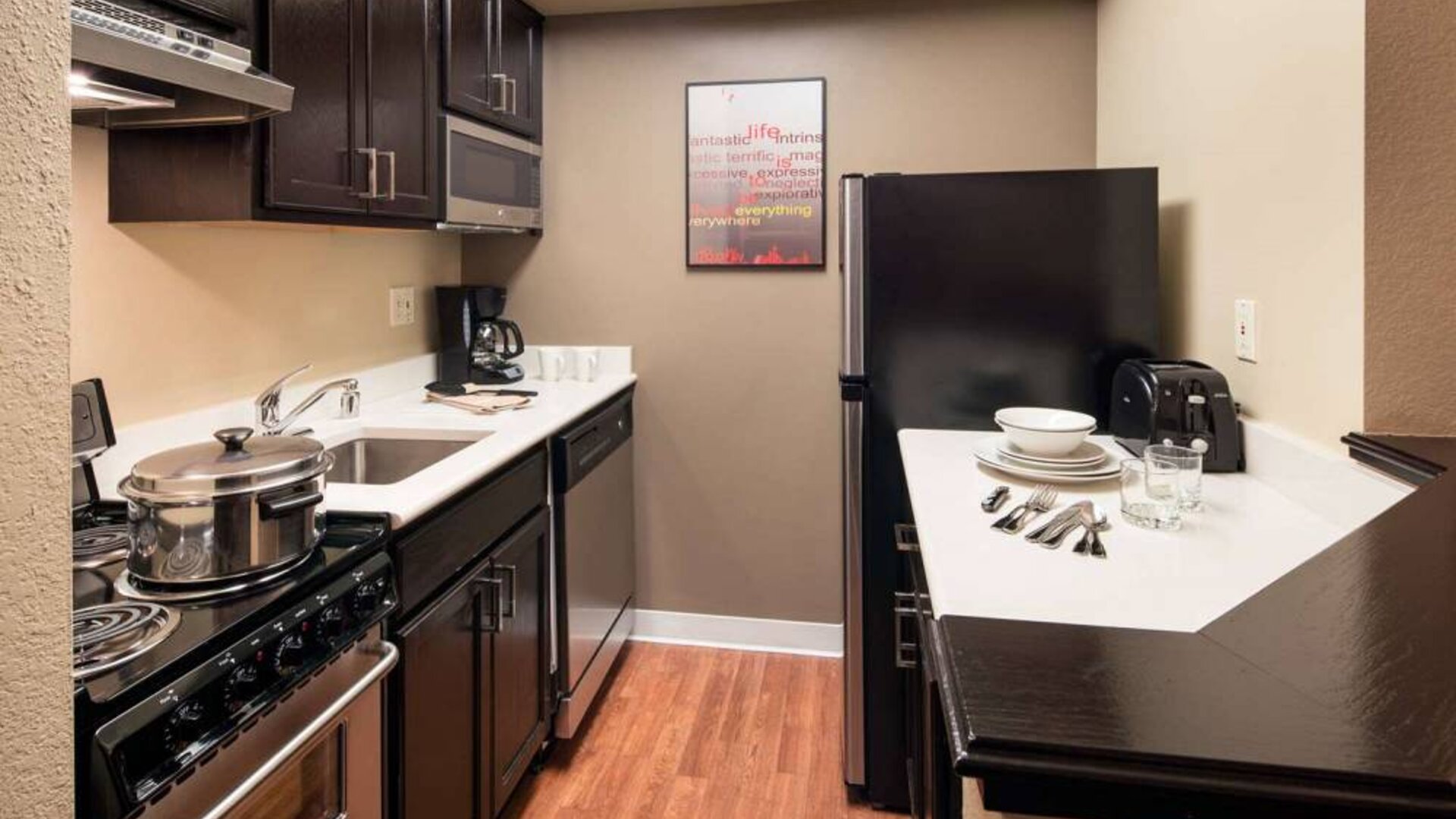 Sonesta Simply Suites Seattle Renton guest room kitchen, furnished with oven, hob, microwave, and fridge-freezer.