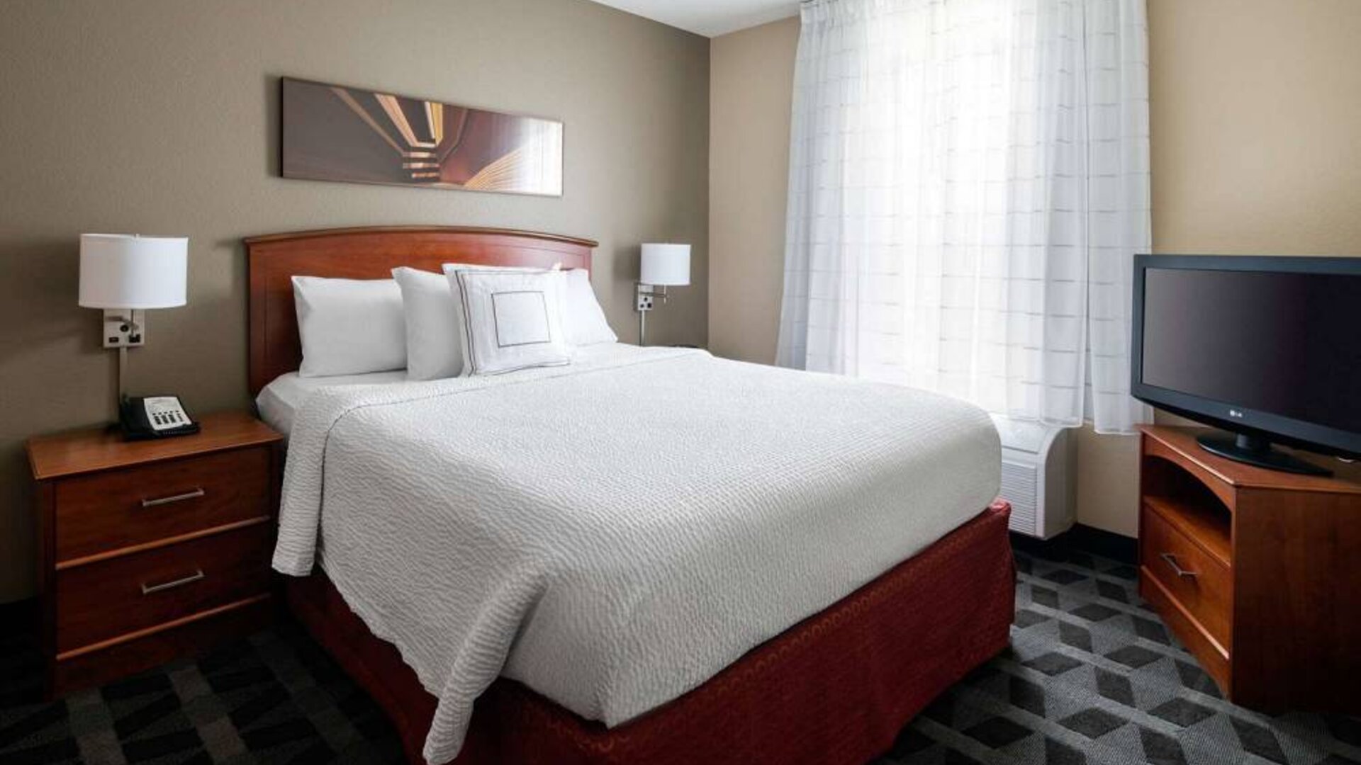 Double bed guest room in Sonesta Simply Suites Seattle Renton, featuring a large window and widescreen television.