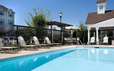 Sonesta Simply Suites Seattle Renton’s outdoor pool is fenced off and has both sun loungers and chairs by the side.