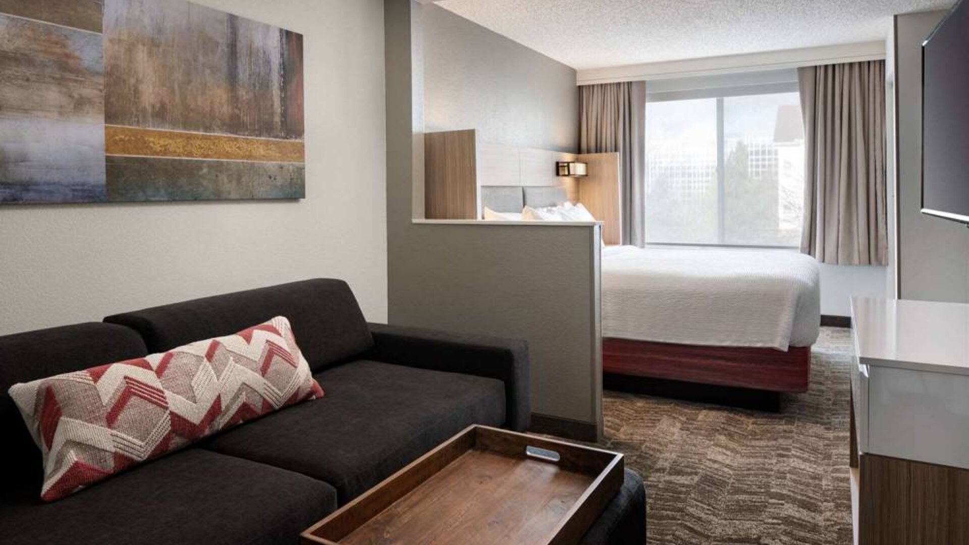 Sonesta Select Seattle Renton double bed guest room, featuring TV, window, and sofa.