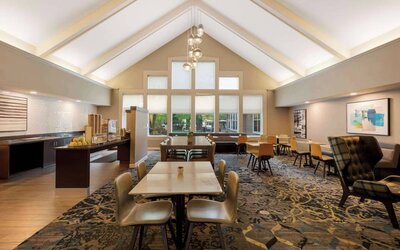 The hotel’s breakfast area is spacious and has large windows, with tables varying from two seats to eight, and art on the wall.