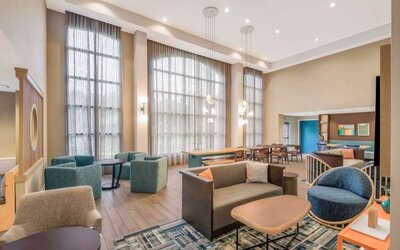 The hotel’s lobby lounge has a high ceiling and full-length windows, comfortable seating including armchairs and sofas, and numerous coffee tables.