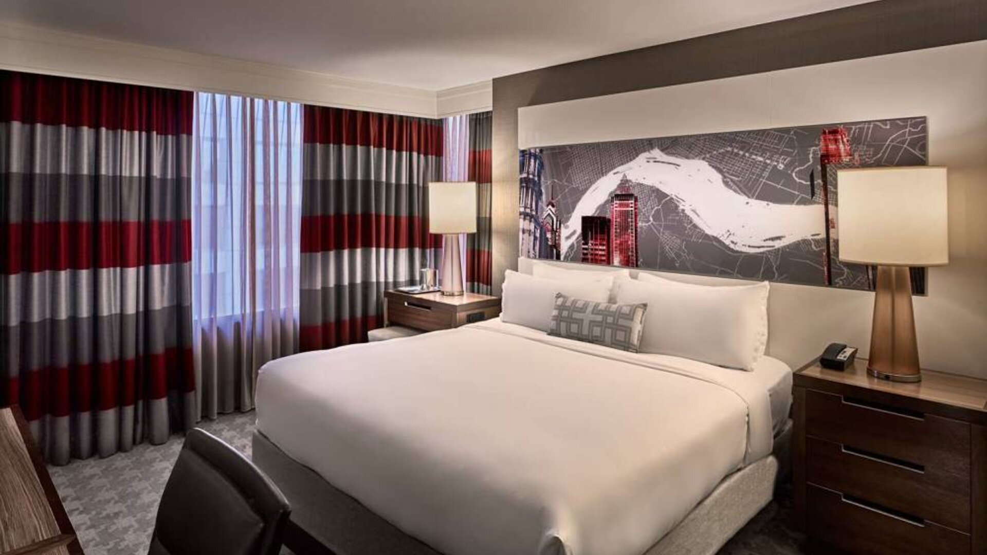 Double bed guest room in Sonesta Philadelphia Rittenhouse Square, including art on the wall, bedside lamps, and a large window.