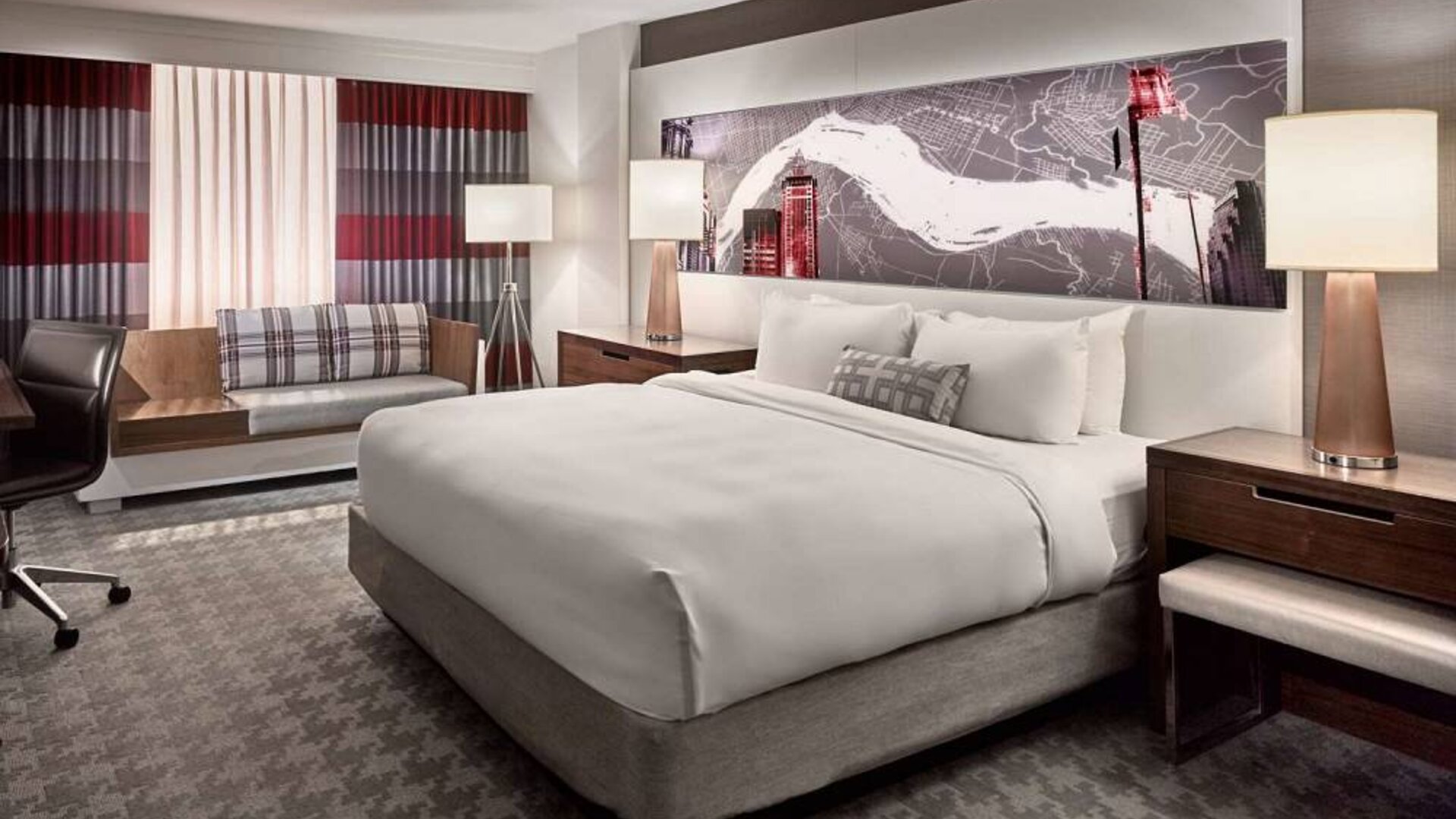 Double bed guest room in Sonesta Philadelphia Rittenhouse Square, including art on the wall, bedside lamps, chair, and a sofa.