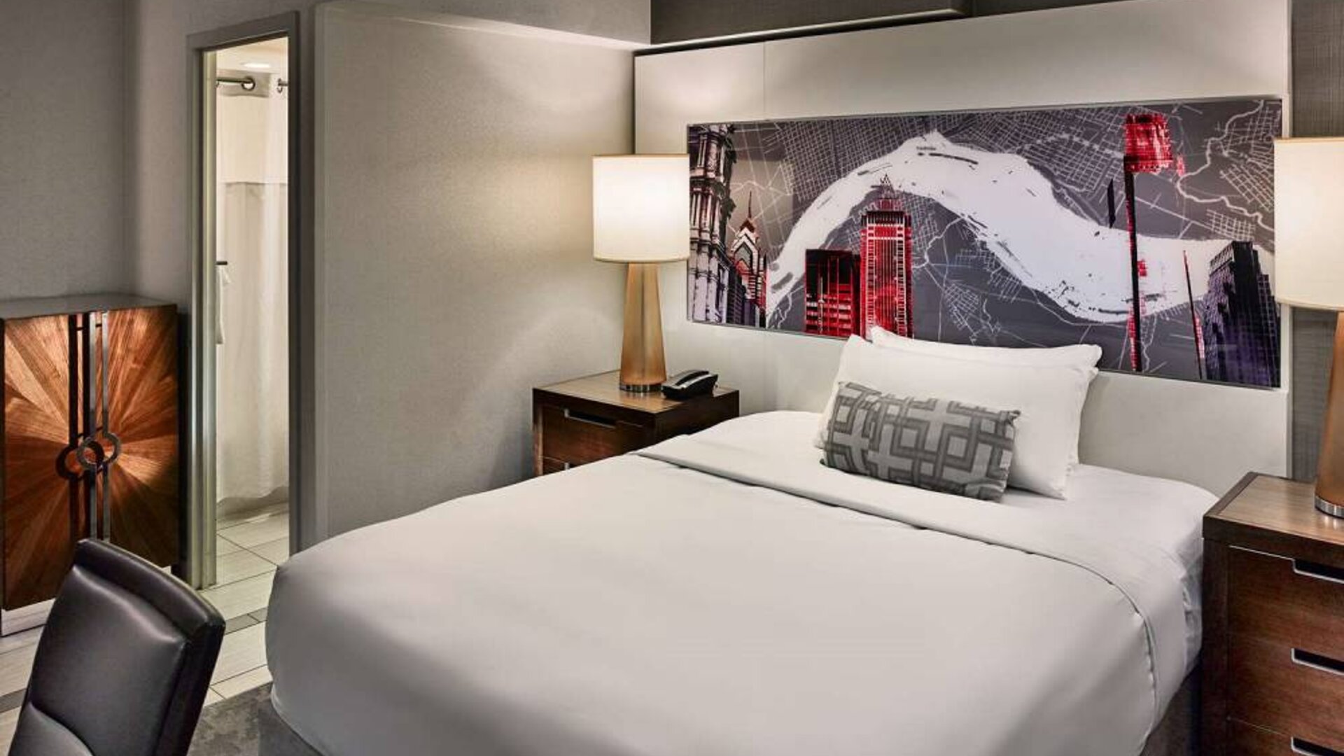Sonesta Philadelphia Rittenhouse Square double bed guest room, featuring art on the wall, chair, and ensuite bathroom.