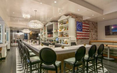 The hotel restaurant has tall stool seating at the bar, an extensive range of beverages, and an artistic 13 star Betsy Ross variant of the Stars and Stripes on the wall.