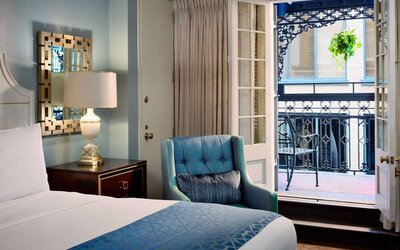 Double bed guest room in Royal Sonesta New Orleans, including armchair and a balcony.