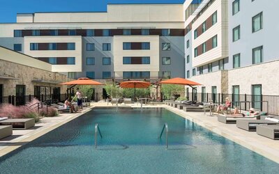 Sonesta Bee Cave Austin’s outdoor pool has sun loungers by the side and shaded seating just a few feet away.