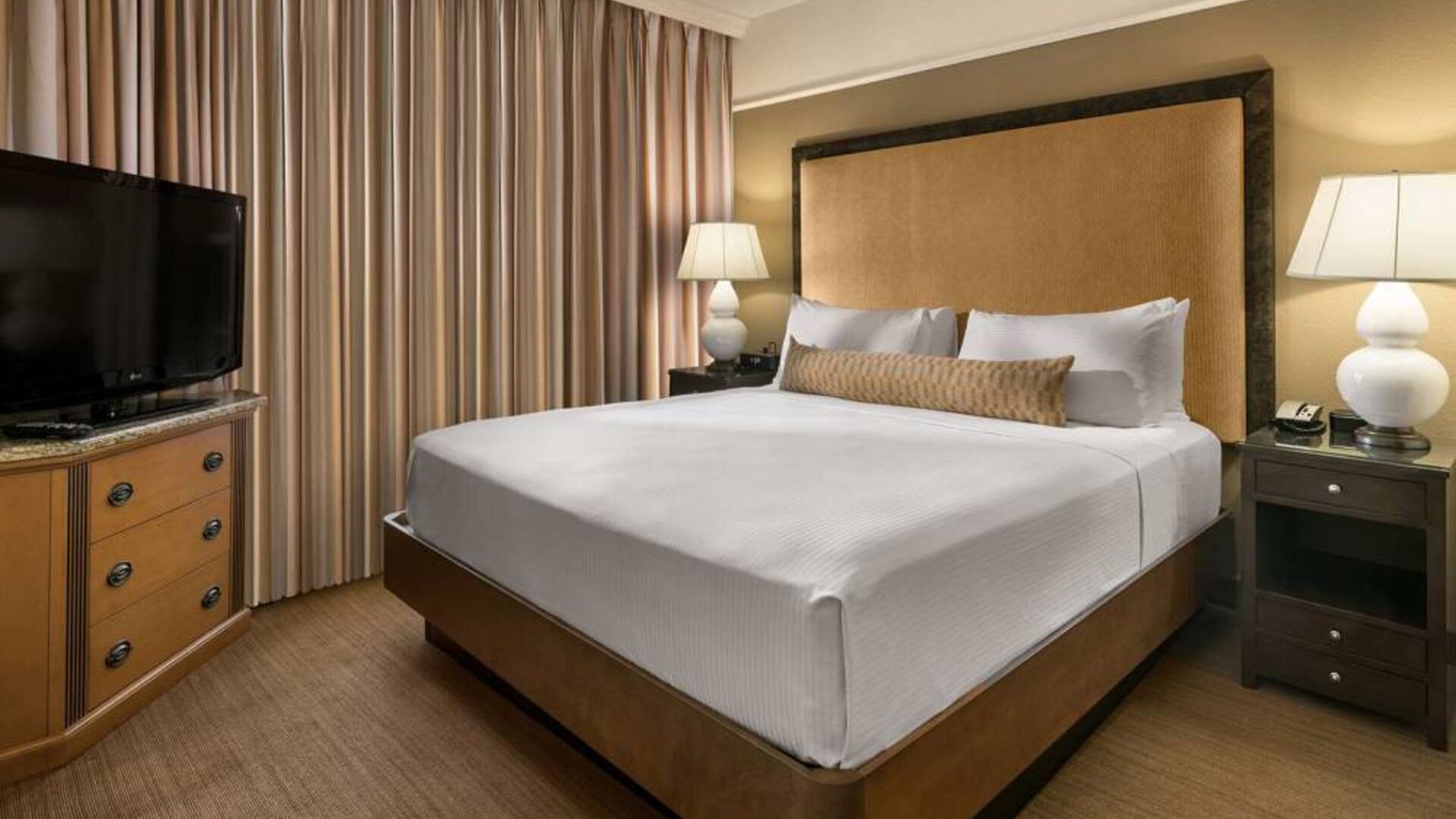 Double bed guest room in Sonesta Suites Scottsdale Gainey Ranch, featuring window, bedside lamps, and television.