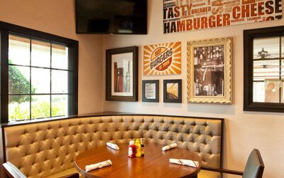 The Burger Place is Sonesta Atlanta Airport South’s on-site restaurant, and includes burger-related art on the wall alongside a widescreen TV, and large windows.
