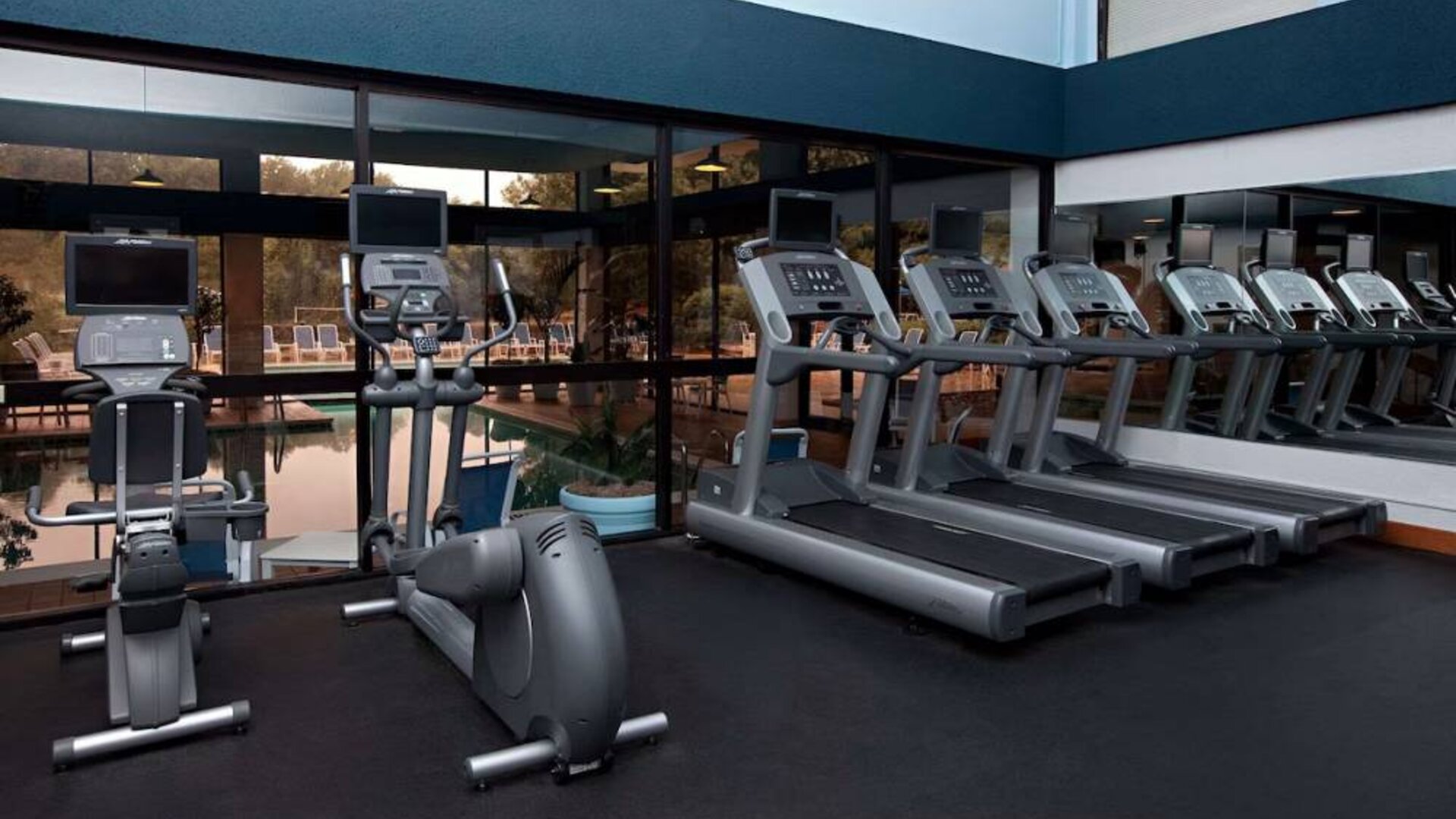 The fitness center at Sonesta Charlotte Executive Park has assorted exercise machines, and large windows that overlook the pool.