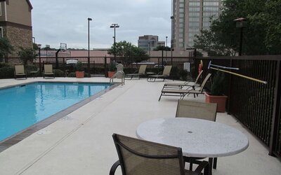 Sonesta ES Suites San Antonio Northwest - Medical Center’s outdoor pool is ringed by a fence, and has nearby tables and chairs, as well as sun loungers.