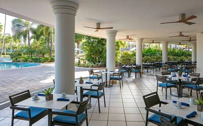 The hotel’s breakfast area has a hard floor, numerous ceiling fans, and small tables within easy reach of the pool.
