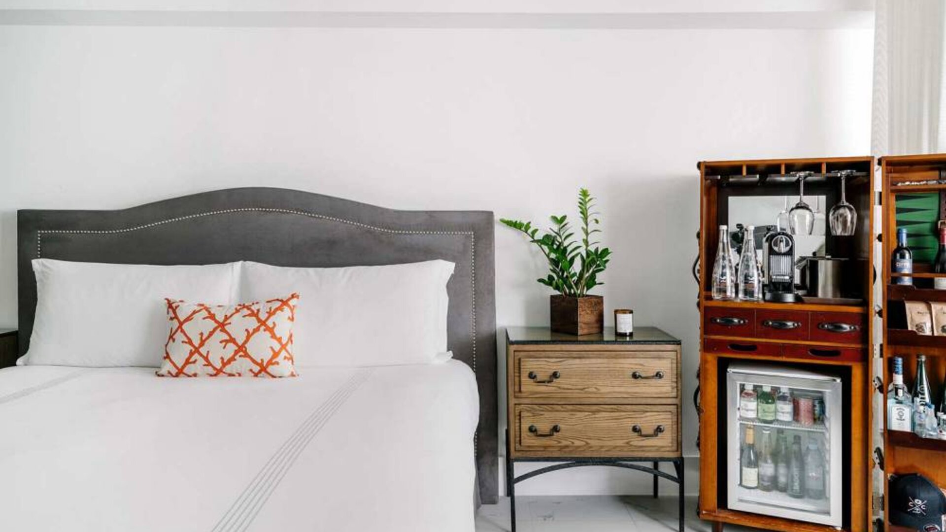 Nautilus by Sonesta double bed guest room, featuring bedside chest of drawers and drinks facilities including a mini-fridge.