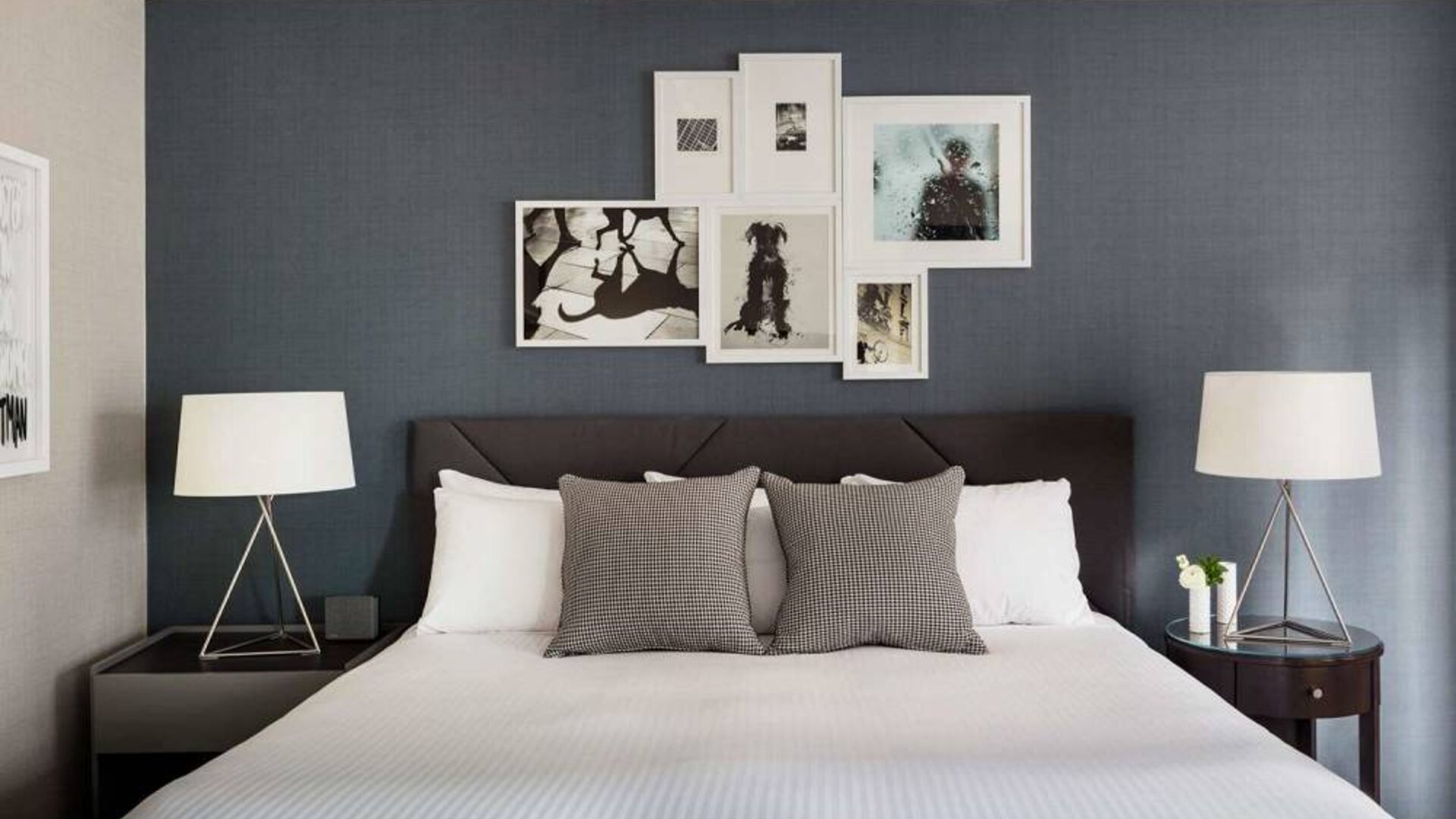 The Shelburne Sonesta New York double bed guest room, with art on the walls and bedside lamps.