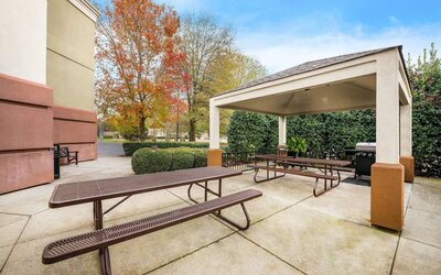 Sonesta Simply Suites Huntsville Research Park’s barbecue facilities has two nearby picnic tables, one within the gazebo and one outside it.