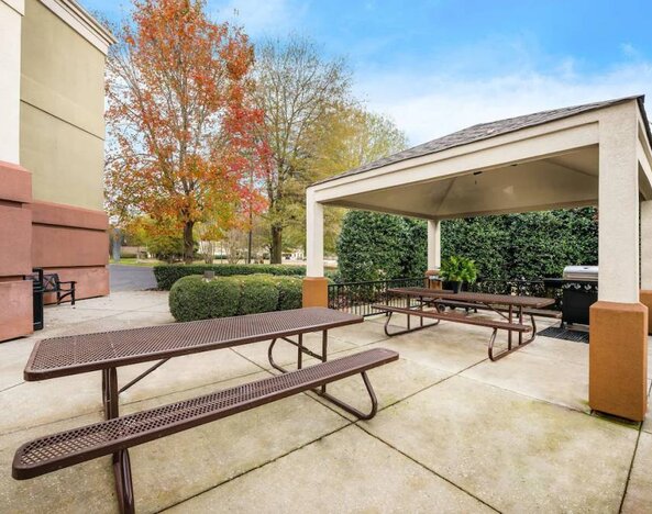 Sonesta Simply Suites Huntsville Research Park’s barbecue facilities has two nearby picnic tables, one within the gazebo and one outside it.
