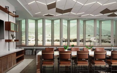 Hotel meeting room, including long table, high ceiling, large windows, and a wall-mounted television.