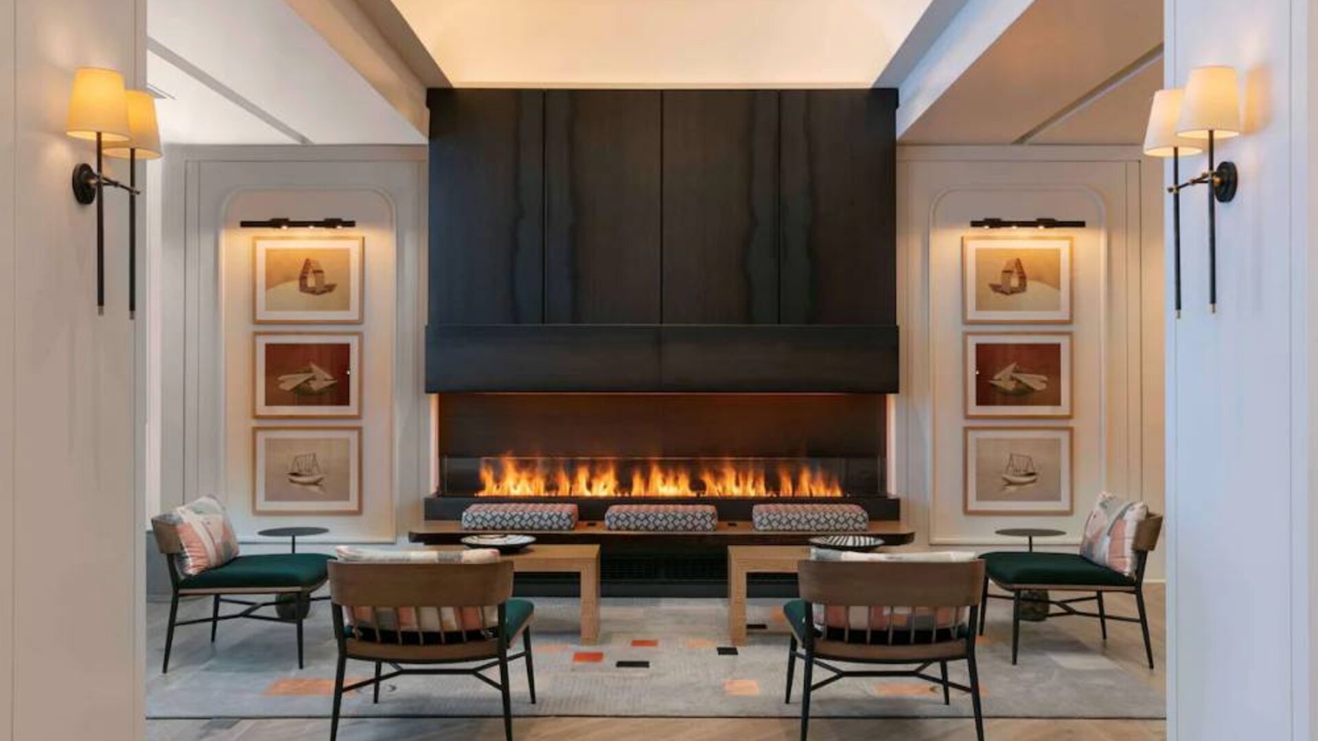 The lobby lounge of Royal Sonesta Chicago Downtown is furnished with comfortable seats and coffee tables close to a fireplace, with art on the walls.