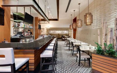 The hotel’s restaurant offers on-site dining, a mix of bar stools alongside small tables and chairs, and multiple widescreen televisions.