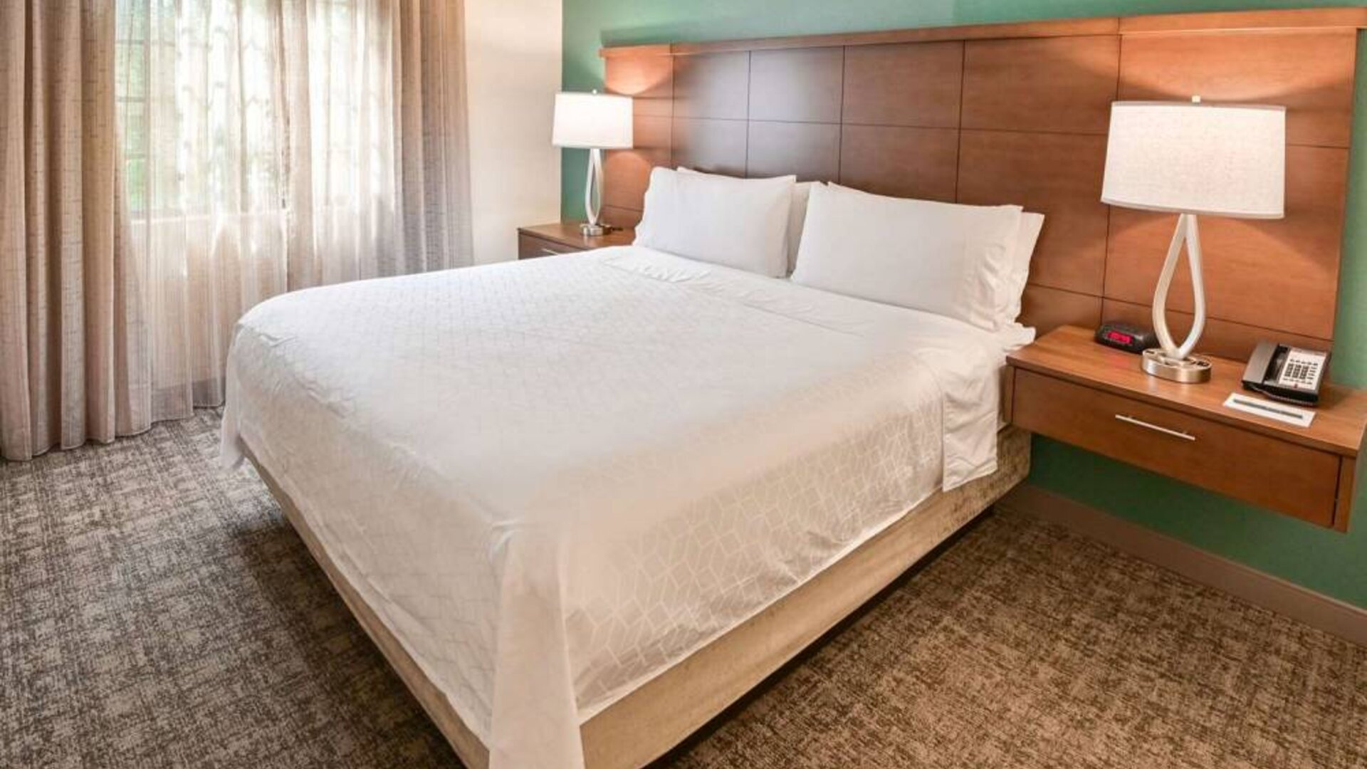 Double bed guest room in Sonesta ES Suites Fort Lauderdale Plantation, including bedside lamps and a window.