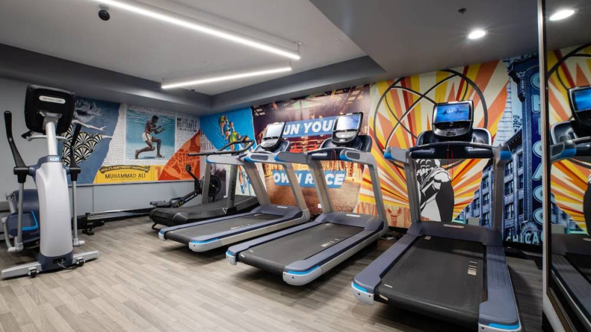 The fitness center in The Allegro Royal Sonesta Hotel Chicago Loop has assorted types of exercise machine and motivational artwork on the wall.