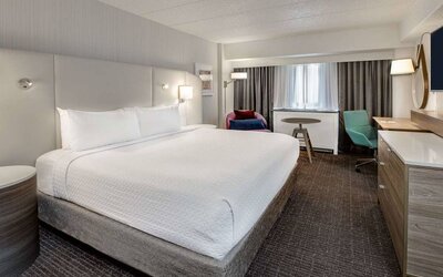 Sonesta Columbus Downtown double bed guest room, featuring armchair, window, and TV, and a workspace desk and chair.