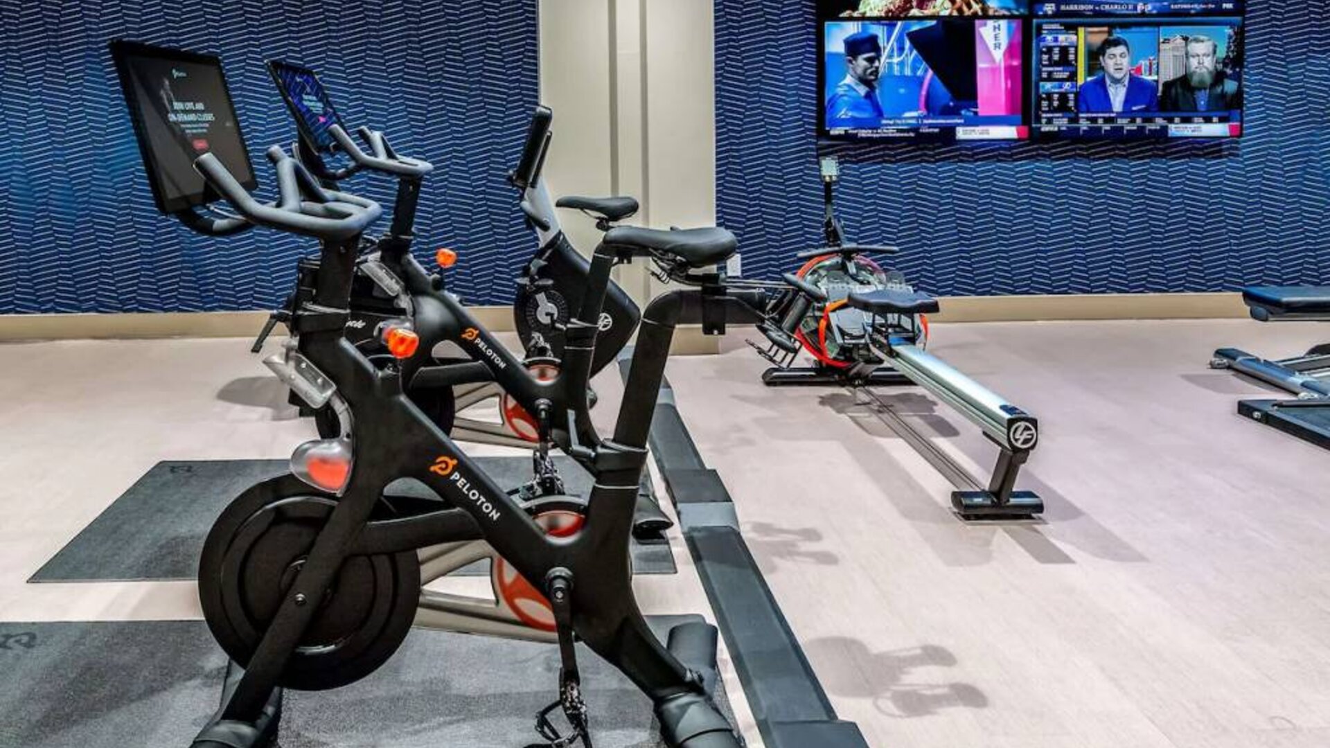 The fitness center in Sonesta Columbus Downtown has an assortment of exercise machines and multiple widescreen TVs on the wall.