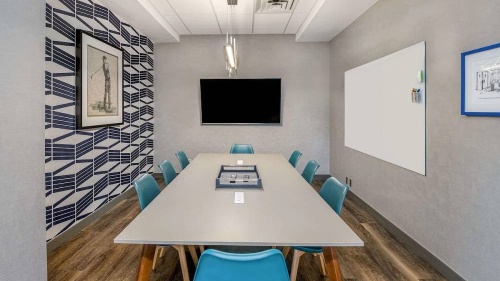 Sonesta Columbus Downtown meeting room, featuring whiteboard and wall-mounted TV, plus a long table and eight chairs.